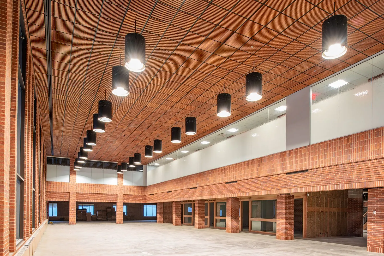 Construction progress inside a building with a wood-slat ceiling