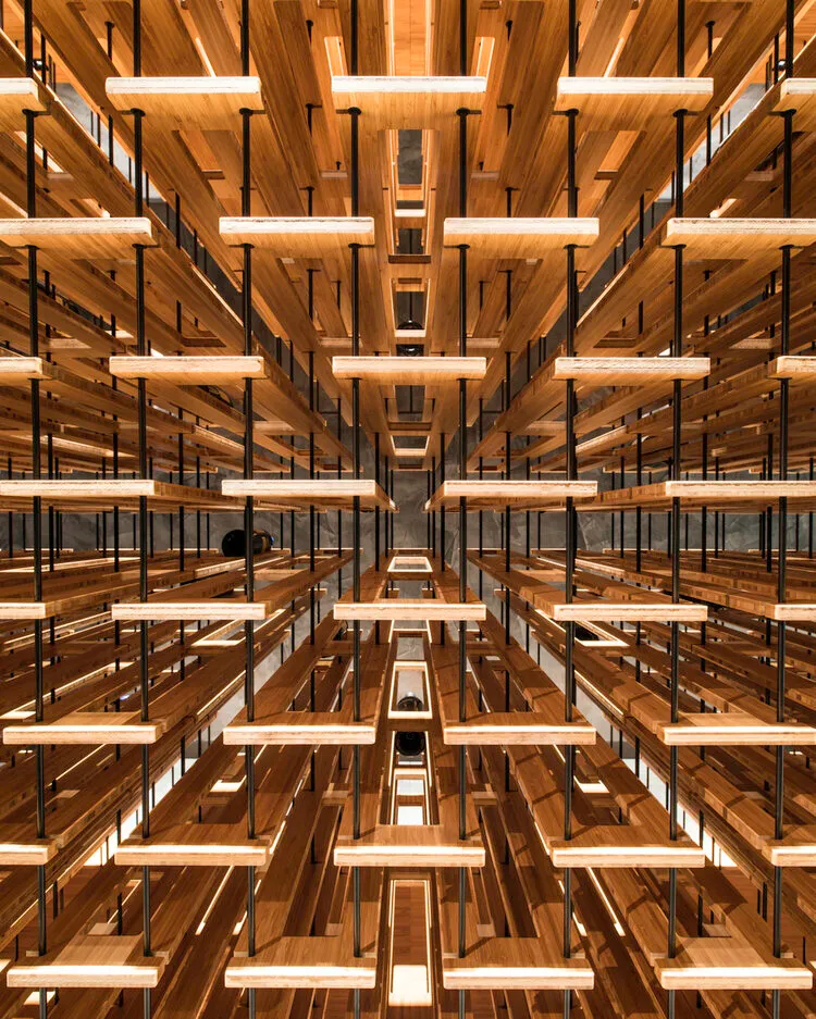 Symmetrical view up into a warm wood-and-light ceiling installation
