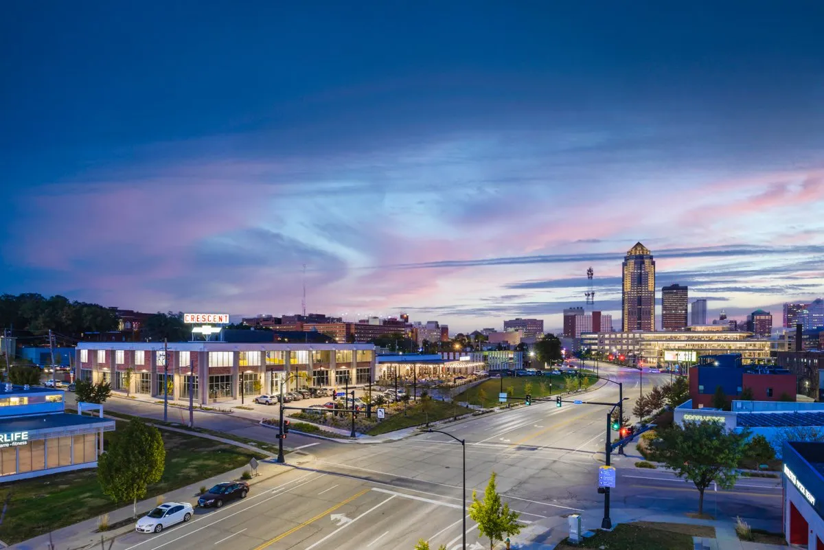 Big Grove Brewery and the Crescent Building at dusk with the Des Moines skyline