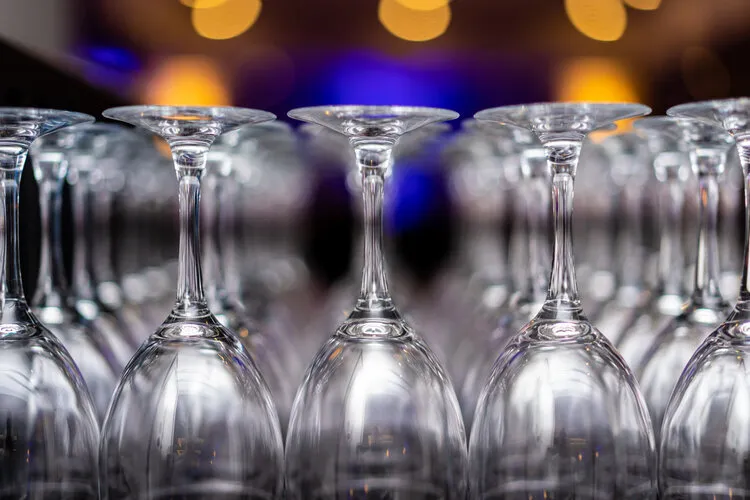 Rows of wine glasses glowing under warm bar lights