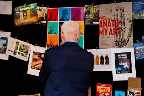 Man studying a wall of posters at a design exhibit