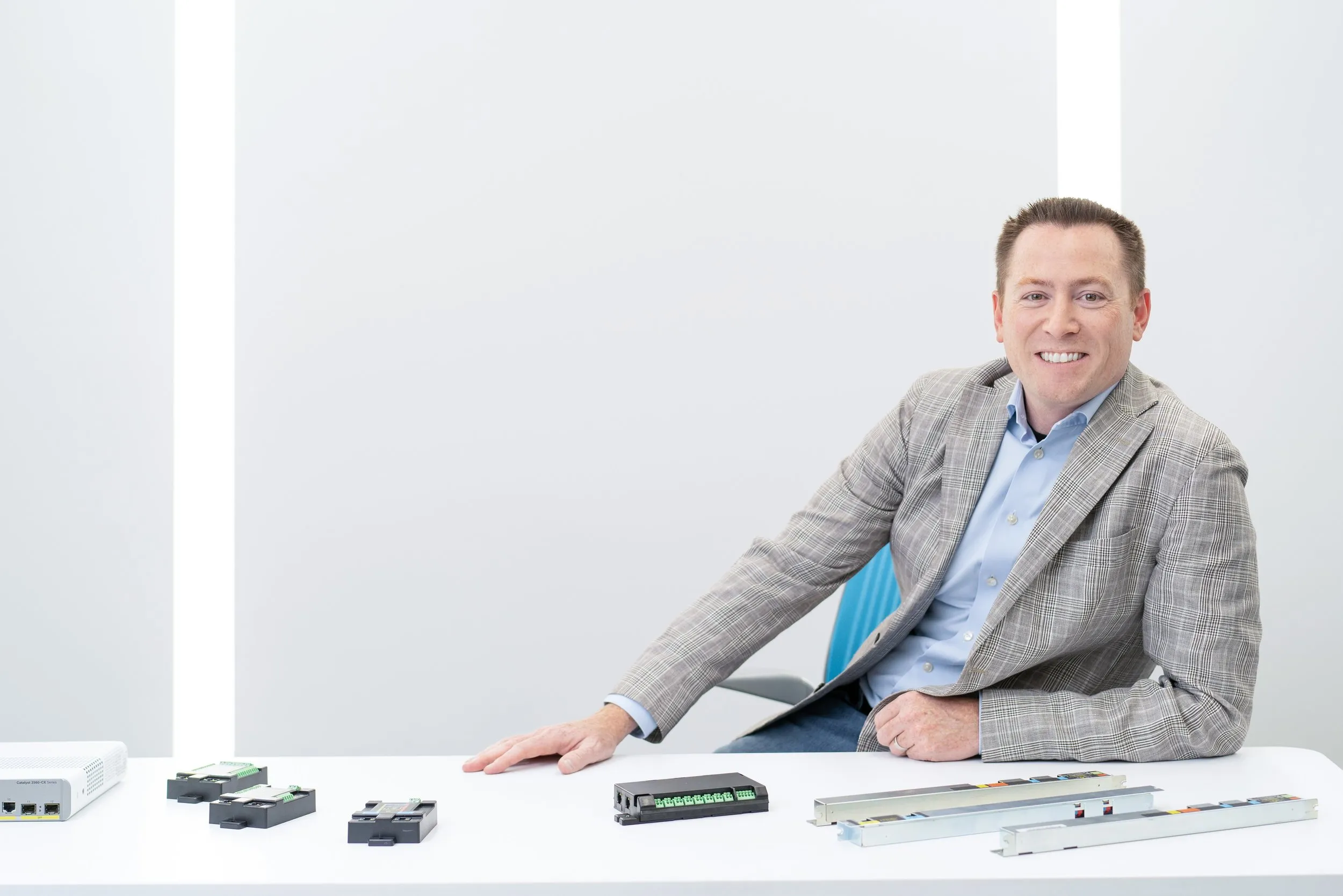 IGOR team member seated with Power over Ethernet products in a bright studio