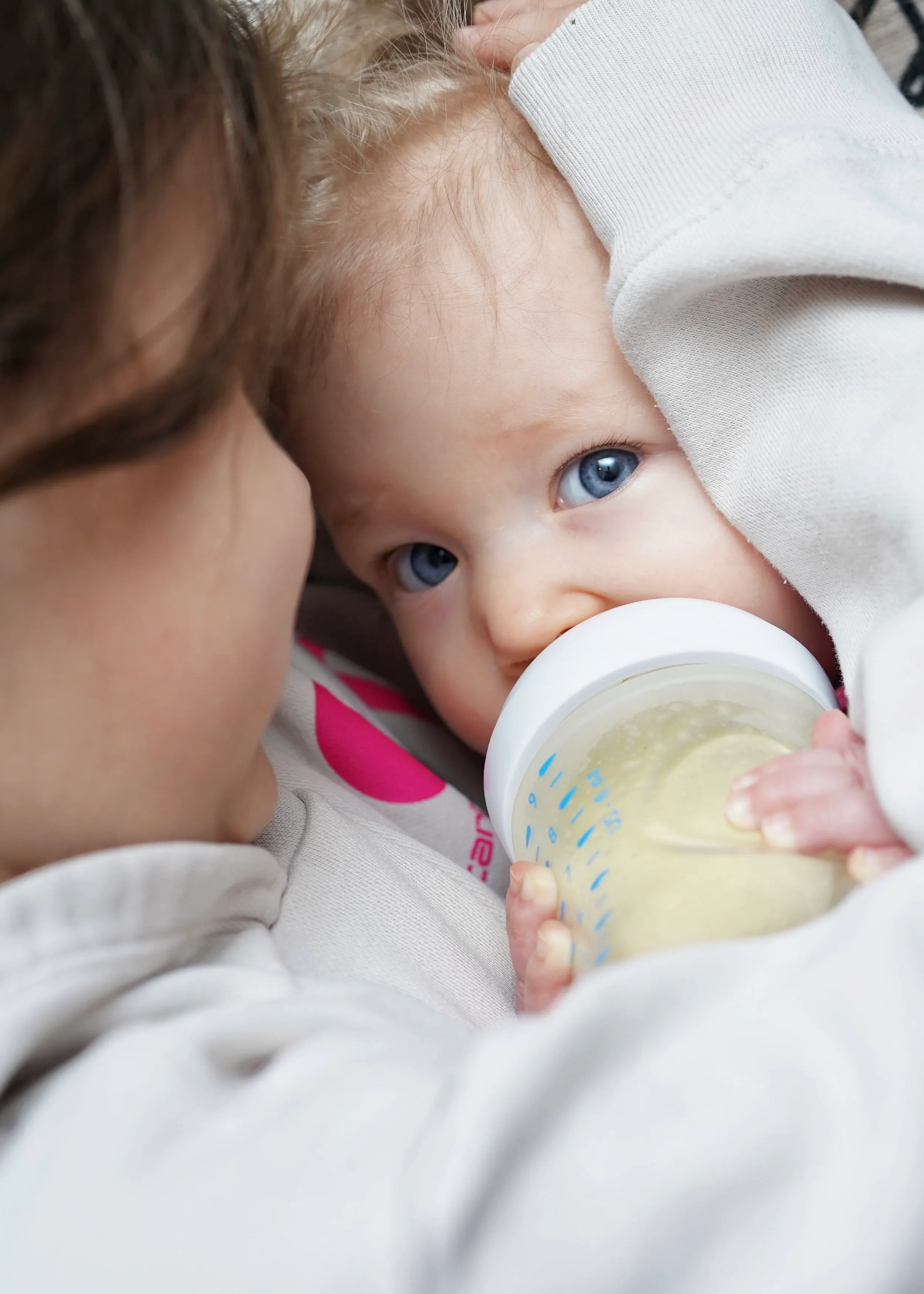 Baby drinking from a bottle, lifestyle portrait