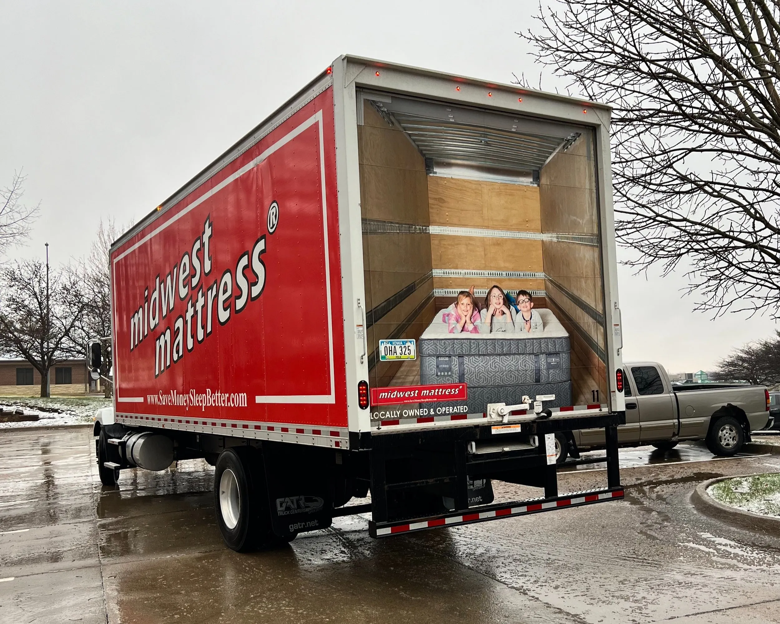 Red Midwest Mattress delivery truck with its rear door open