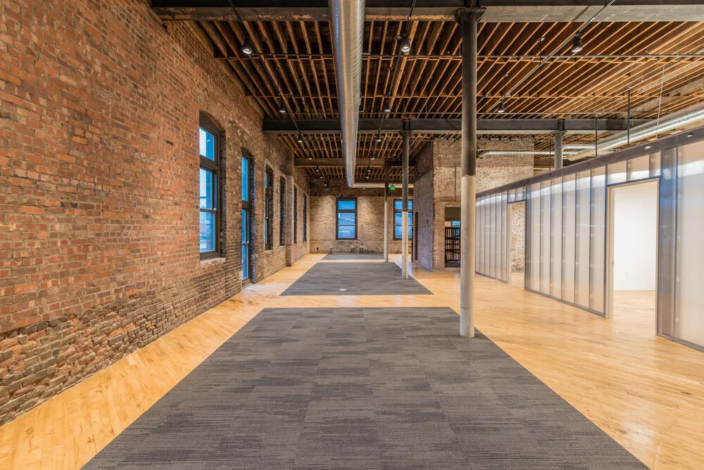 Open office corridor with exposed brick and timber ceiling