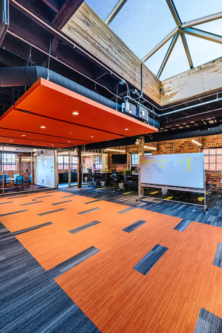 Forge building interior with an orange ceiling feature under skylights